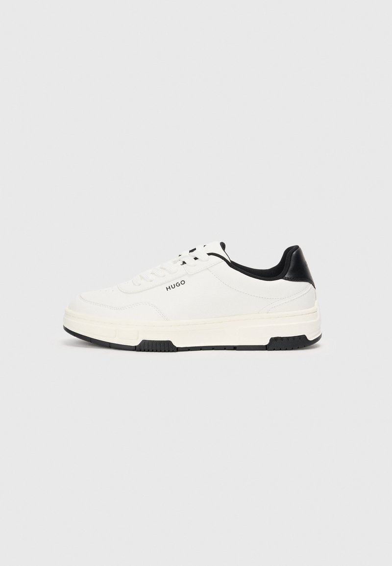 White sneaker with black heel and accents, textured fabric upper, rubber sole, and flat laces. Features logo on the side.