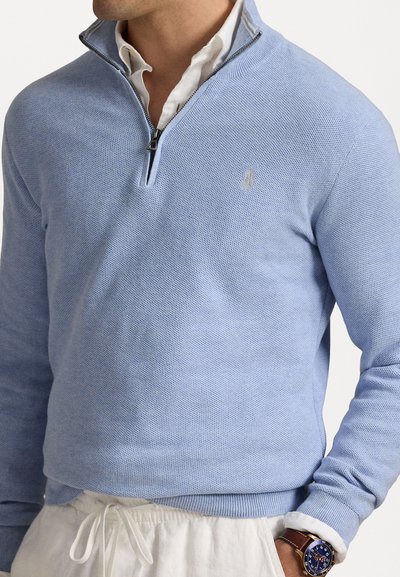 Pull-over zippé à quart en coton bleu clair avec un motif tricoté texturé. Présente un logo discret sur la poitrine et des bords-côtes aux poignets et à l'ourlet.