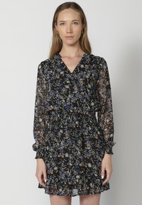 Rochie neagră cu model floral, cu mâneci lungi și puffate, decolteu în V, talie strânsă și tiv volănaș, confecționată dintr-un material ușor.