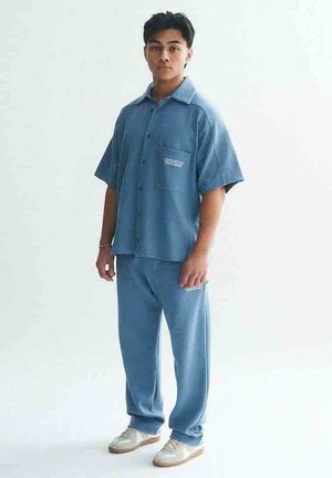 LOGO - Tracksuit bottoms - light blue
