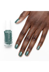 Bottiglia di smalto per unghie verde opaco con un cappuccio bianco accanto a una mano con unghie curate e dipinte nello stesso colore verde.