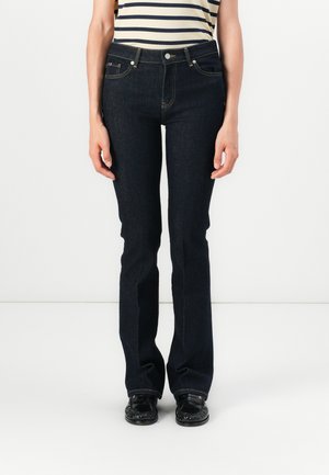 Mørke denimjeans med rett ben-snitt, med et klassisk fem-lomme design og front knappelukking. Brukt med en stripete topp.