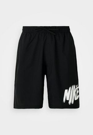 Shorts noirs arrivant au genou avec une taille élastique et un lien, arborant un grand logo Nike blanc en bas à gauche de la jambe.