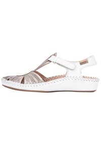Sandale blanche avec un design découpé, en cuir, à bride ajustable et avec des coutures contrastées le long de la semelle. Présente une texture tissée subtile.