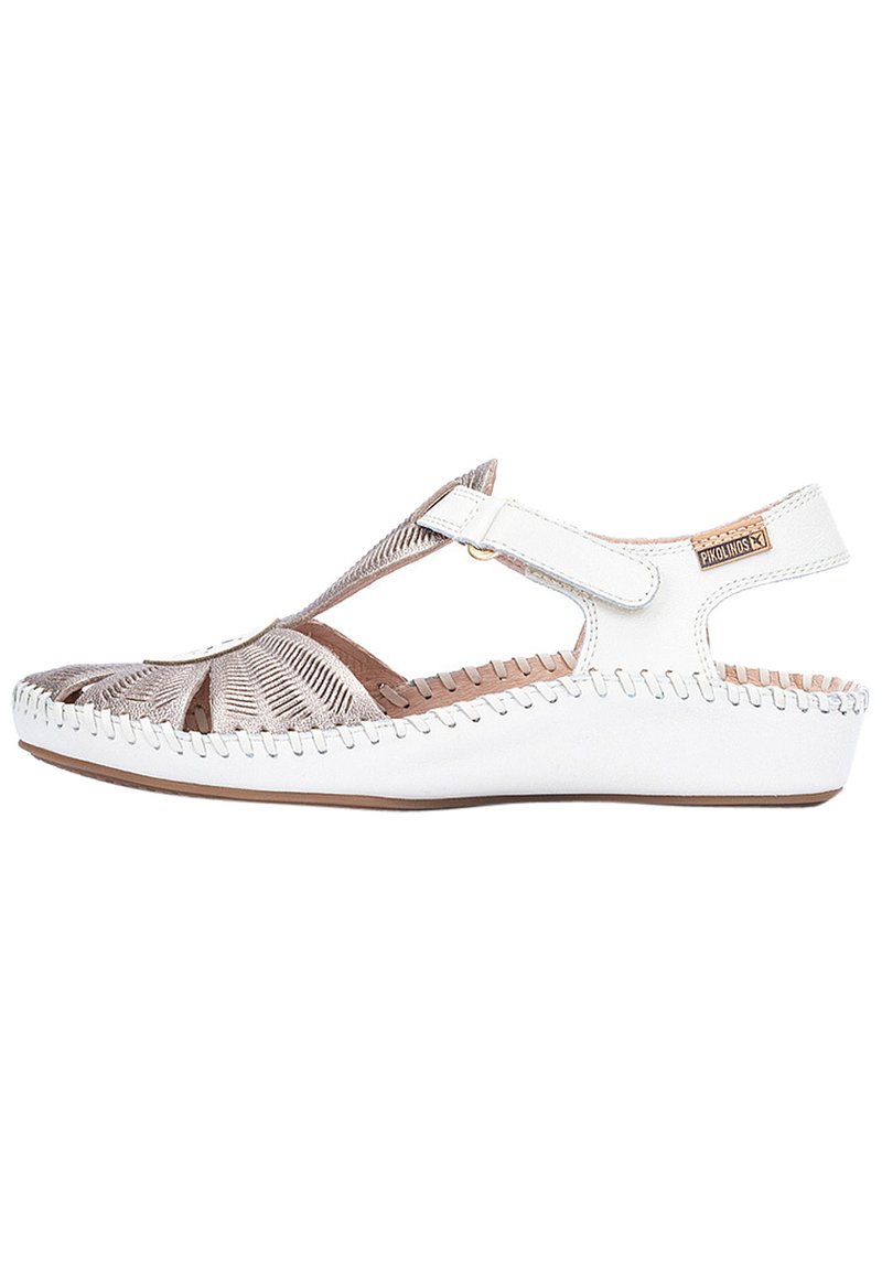 Sandale blanche avec un design découpé, en cuir, à bride ajustable et avec des coutures contrastées le long de la semelle. Présente une texture tissée subtile.