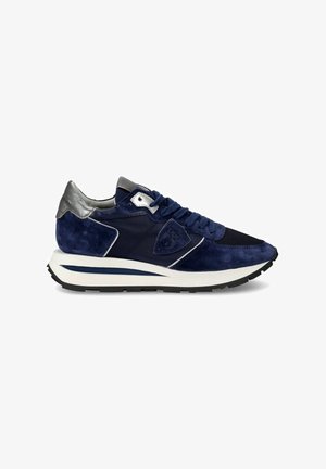 Donkerblauwe suède sneakers met zilveren accenten, gestructureerd mesh, gewatteerde tong en een chunky witte zool met een zwarte onderkant.