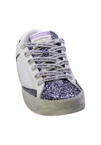 Zapatilla blanca con detalle de purpurina plateada en la punta, cordones grises con el texto "CRIME SNEAKERS" y suela gris mate.
