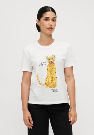 T-shirt en coton blanc avec un graphisme ludique de léopard en jaune et noir, accompagné du texte "MAUVAISES ONDES" et "NE PAS S'ASSOCIER À MON ROUGE À LÈVRES."