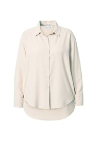 Camisa abotonada de color beige claro con mangas largas, que presenta pequeños lunares oscuros y un dobladillo ligeramente redondeado. Tejido suave y tejido.