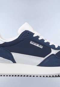 Baskets pour homme en bleu marine avec des accents blancs, dotées d'un dessus en daim et en nylon, d'un laçage et d'une semelle en caoutchouc texturée.