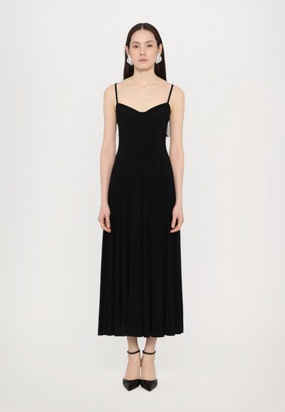 Musta, hihaton mekko, jossa on istuva bodice ja leveähelmainen hame. Valmistettu sileästä kankaasta, jossa on sydänmainen pääntie ja ohuet olkaimet.