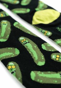 Calze nere con un motivo di cetriolini verdi, alcuni con espressioni facciali. Il materiale sembra morbido con una texture liscia.