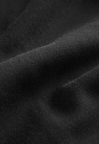 Must mustrilineid kangas, millel on peen herringbone muster, pehme pind kerge läikega, volditud õrnades lainetes.