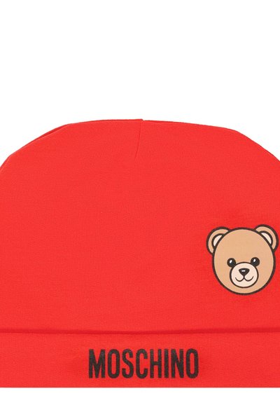Czerwony beanie z miękkiego materiału, z nadrukowaną buźką derżka misia i napisem "MOSCHINO" w czerni na dole. Cylindryczny kształt.