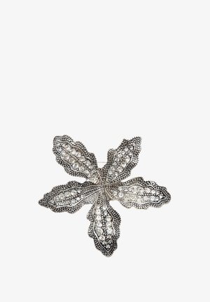 Sølvbroche formet som et femtakkede blad med indlagte klare rhinsten og detaljerede teksturerede kanter på en hvid baggrund.