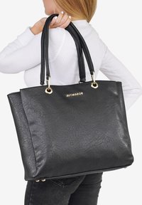 Borsa a spalla nera in ecopelle con doppio manico nero, dettagli in oro e un logo dorato ben visibile sul fronte. Superficie strutturata.