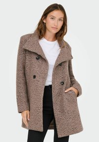 Brauner texturierter Mantel mit doppelter Knopfleiste, großem Kragen und zwei frontalen Taschen. Verfügt über schwarze Knöpfe und eine lässige Passform.