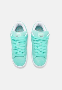 Zapatillas Puma de ante verde menta con cordones a juego, suela de goma blanca y plantilla de turquesa con estampado. Logo cuadrado en la lengüeta.