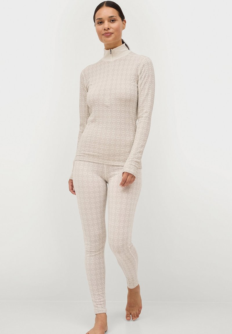 Lichtbeige thermoset bestaande uit een langmouwtop met hoge kraag en bijpassende strakke leggings, beide met een reliëfpatroon.