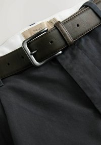 Black pants made of smooth fabric, featuring a brown leather belt with a rectangular silver buckle, and white waistband lining.