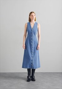 Denim midi mekko, jossa on V-kaula-aukko, nappisuljenta ja sivutaskut. Mekossa on istuva yläosa ja levenevä hame, vaaleansinisen sävyssä.