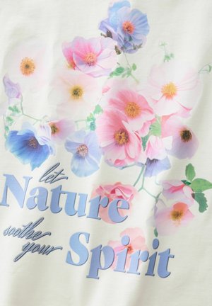 Vit t-shirt av tyg med blommönster i rosa, blått och lila. Texten lyder "låt naturen lugna din själ" i blått.
