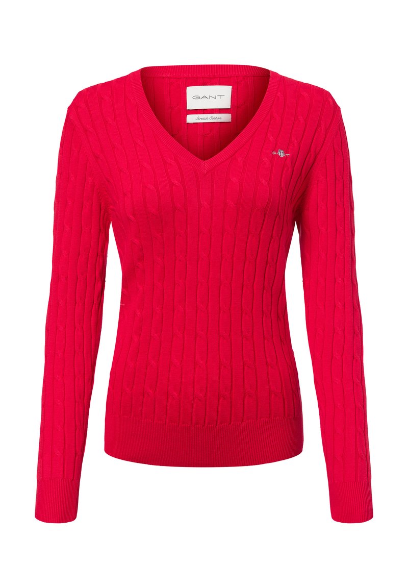 Roter Strickpullover mit V-Ausschnitt, versehen mit einem Zopfmuster. Lange Ärmel und gerippter Saum. Kleines Logo auf der linken Brustseite.