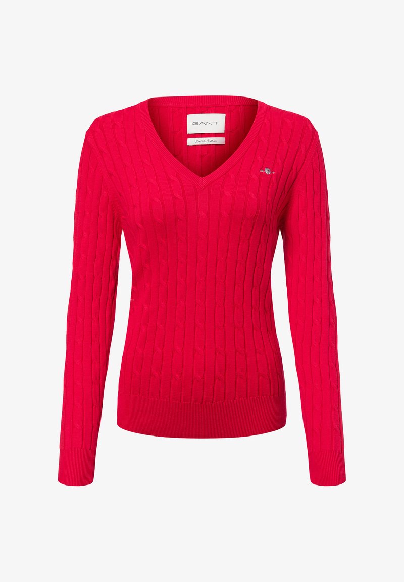 Roter Strickpullover mit V-Ausschnitt, versehen mit einem Zopfmuster. Lange Ärmel und gerippter Saum. Kleines Logo auf der linken Brustseite.