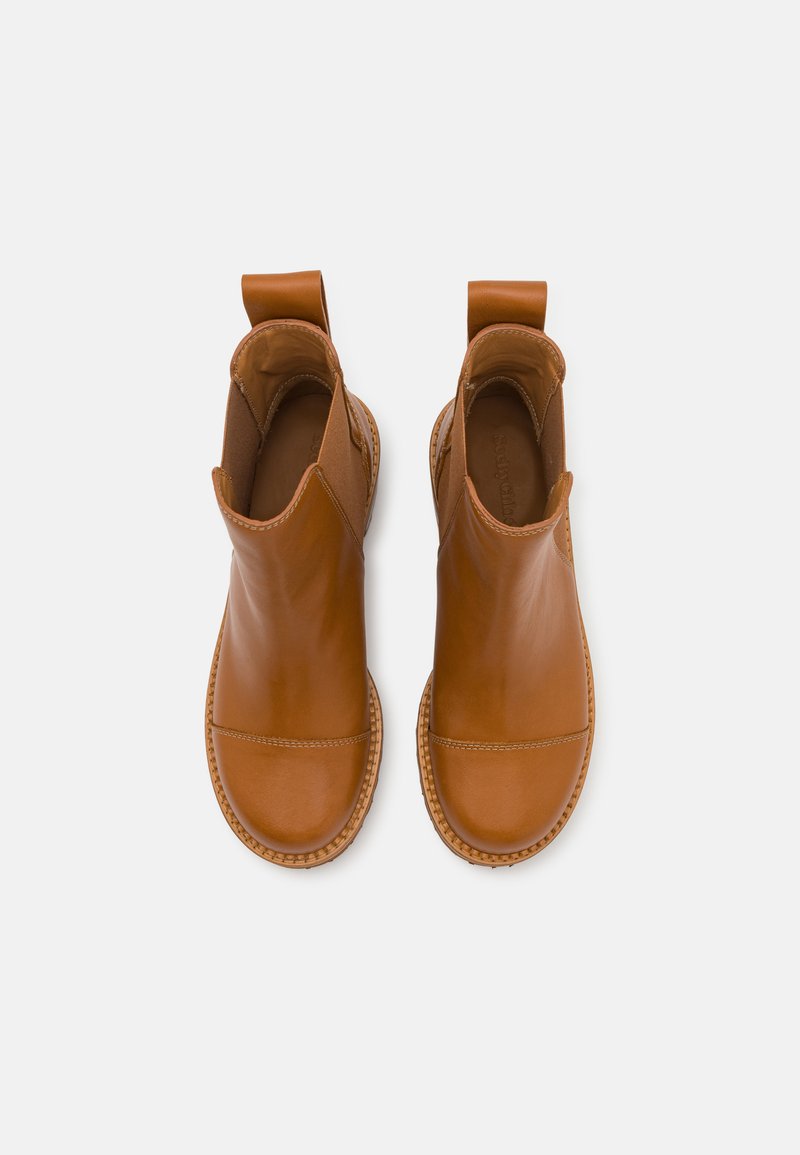 Stivali alla caviglia in pelle marrone con una finitura liscia, pannelli laterali elastici e linguette per il sollevamento, caratterizzati da una suola intrecciata per dettaglio e texture.