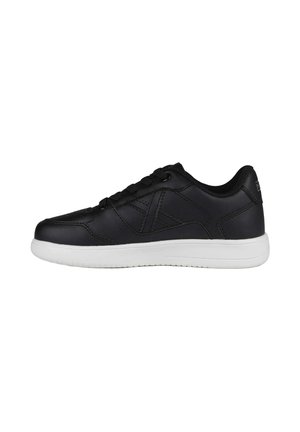 Zapatilla negra de perfil bajo con cordones negros y suela blanca vista desde el lado exterior sobre fondo blanco.