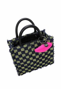 Sac à main tissé à motif à carreaux bleu marine et vert, avec des poignées noires, un détail de franges et un charme en forme de lèvres roses avec un anneau argenté.