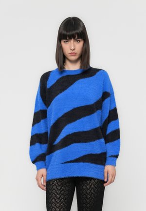 Maglione fuzzy a righe blu e nere con collo tondo e maniche lunghe, abbinato a leggings neri a trama. Morbido, con una vestibilità rilassata.