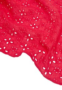 Czerwona bawełniana tkanina z kwiatowymi wzorami ażurowymi, charakteryzująca się wycięciami i lekką, fakturowaną powierzchnią. Odpowiednia do odzieży lub akcesoriów.