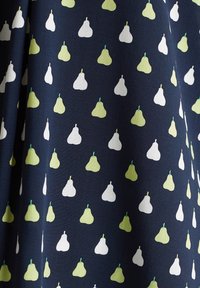 Tissu bleu marine avec un motif répétitif de petites formes de poire vertes et blanches, espacées uniformément en rangées alternées.