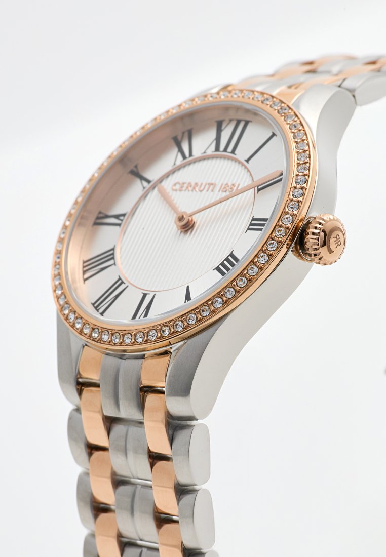 Zegarek Cerruti 1881 z różowym złotym bezel z kryształami, białą teksturowaną tarczą, cyframi rzymskimi oraz dwukolorową bransoletą metalową.