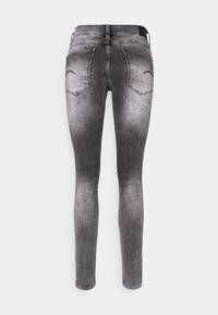 Jeans skinny de mezclilla gris con un lavado desgastado, que cuentan con bolsillos traseros y una cinturilla estándar. Textura suave con ligero estiramiento. Sin adornos.