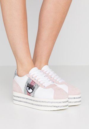 White and pink platform sneakers with glittery accents, featuring an eye design on the side and a textured suede upper. Classic lace closure.