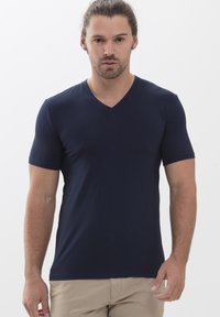 T-shirt bleu marine à manches courtes en V, fabriqué en tissu lisse, avec un design ajusté et des détails de couture minimalistes.