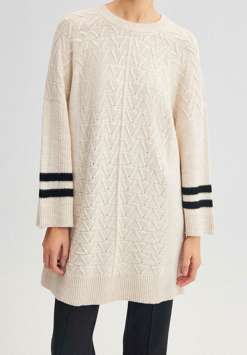 Maglione lavorato a maglia in crema con un motivo triangolare testurizzato, caratterizzato da dettagli a strisce bianche e nere sulle maniche e un orlo a costine.