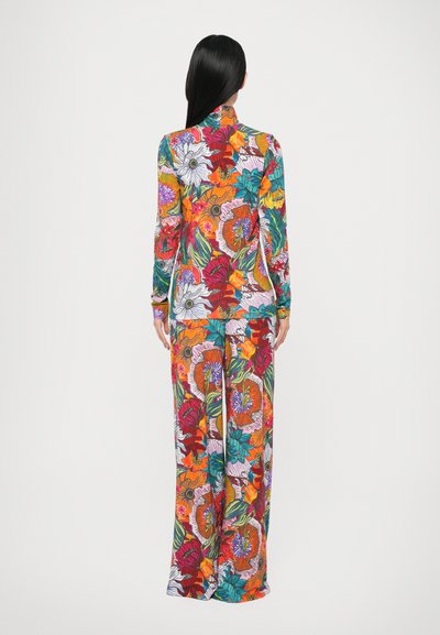 Salopetă florală lungă, cu mâneci lungi, având culori vibrante precum roșu, portocaliu și albastru-verzui. Fabricată dintr-un material neted și elastic.
