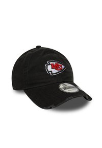 Black adjustable baseball cap with Kansas City Chiefs arrowhead logo in red and white on front, slightly distressed brim.