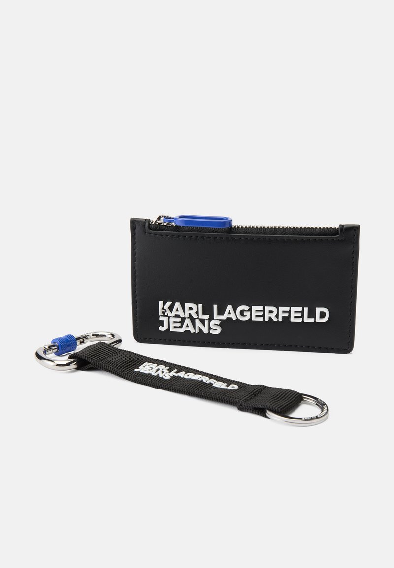 Juodas stačiakampis kortelių laikiklis iš lygaus medžiagos su sidabriniu "KARL LAGERFELD JEANS" logotipu, užtrauktuku uždaromas, ir nuimama audinio raktų pakabuko su mėlyna akcentu.