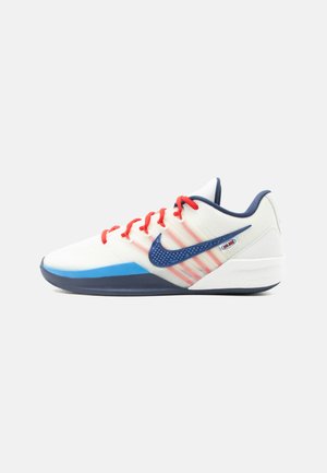 Weißer Nike Sneaker mit niedrigem Schnitt, blauer Sohle und Swoosh, roten Schnürsenkeln und dunkelblauem Kragen, seitlich auf einfachem Hintergrund dargestellt.