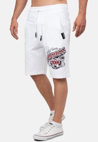 Witte katoenen shorts met een grafische print in rood en zwart. Elastische tailleband met trekkoord en zijzakken. Casual ontwerp.