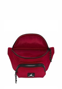 Borsa di stoffa rossa con un compartimento superiore chiuso da cerniera e una tasca frontale più piccola. Hardware della cerniera nero e dettaglio logo sul fronte.