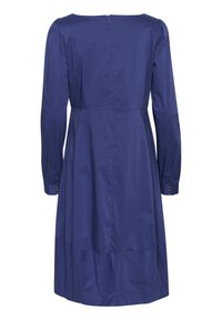 Vestido de manga larga color azul marino que presenta un cuerpo ajustado, con fruncidos en los hombros y un dobladillo a mitad de pantorrilla, con una cremallera oculta en la parte posterior.