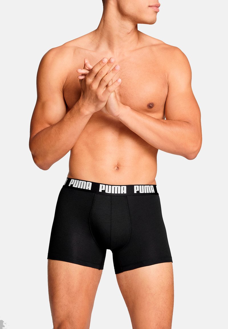 Schwarze Boxershorts aus weichem Stoff mit einem elastischen Bund in Kontrastfarbe, der mit weißer Markenschrift versehen ist. Eng anliegendes, modernes Design.