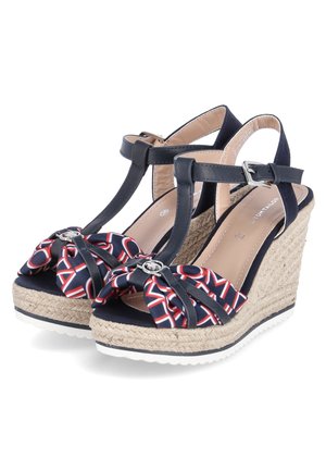 Sandales compensées bleu marine avec brides à la cheville, talons enveloppés de jute et nœuds en tissu avec motif rouge et blanc sur la zone des orteils.