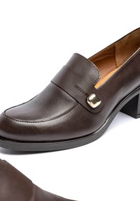 Braune Loafers aus Leder mit glatter Oberfläche, ausgestattet mit einem dekorativen Riemen und goldfarbenen Beschlägen. Blockabsatz, runde Zehenpartie, schlichte Nahtdetails.