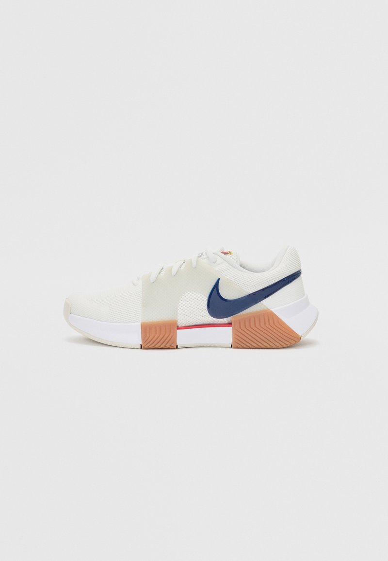 Nike atletske tenisice s gornjim dijelom od bijele mrežice, mornarskom plavom swoosh logotipu, prozirnim bočnim panelima i teksturiranom breskvastom gumom za potplat.